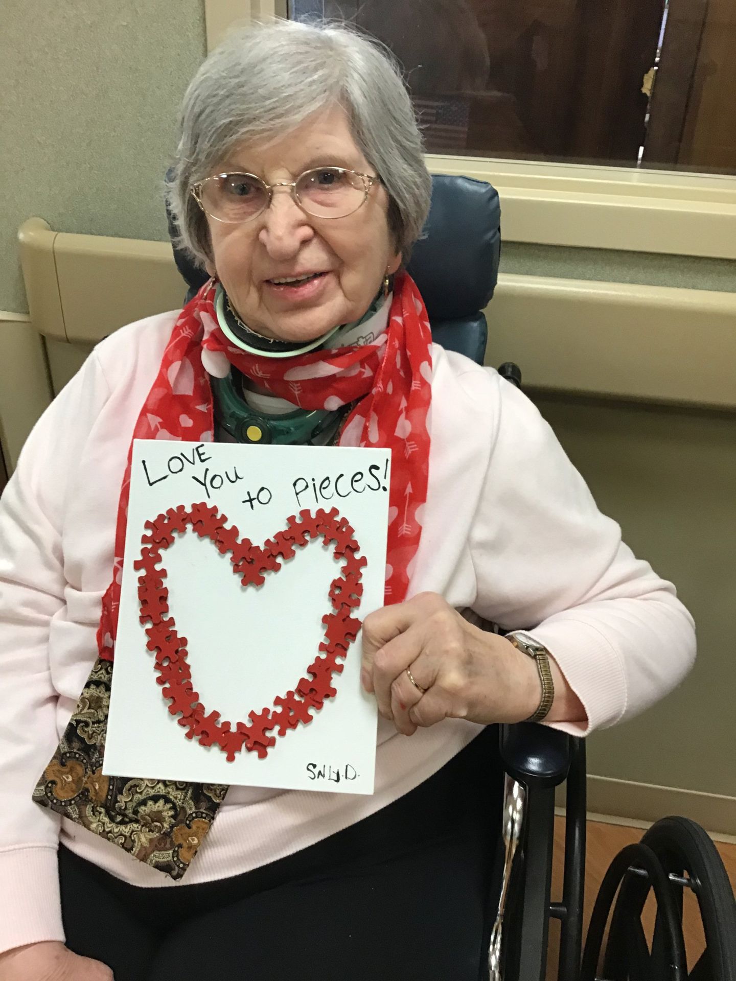 Elder showing off her Valentine's Day craft at Lenawee Medical Care Facility in Adrian, MI