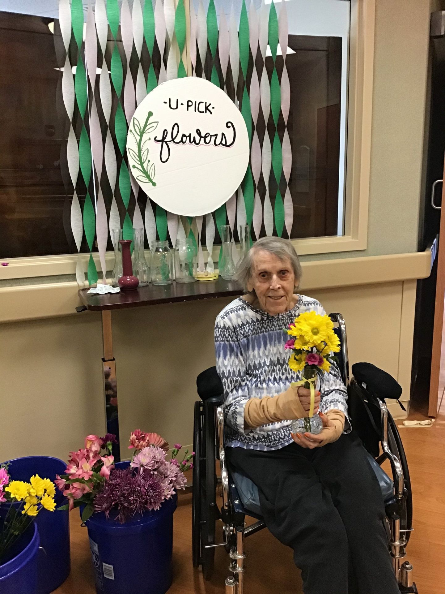 Elder holding flowers at a You Pick Flower station at Lenawee Medical Care Facility in Adrian, MI