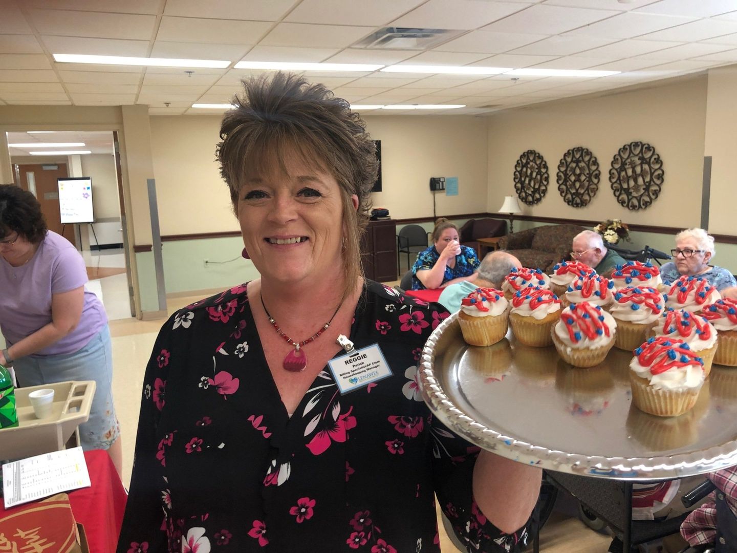Staff member handing out Fourth of July cupcakes and Santa for Christmas at Lenawee Medical Care Facility in Adrian, MI
