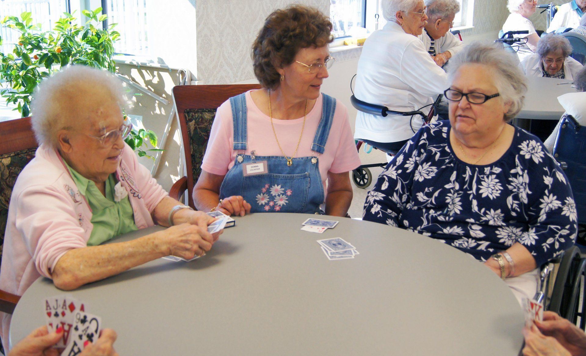 Woman Volunteering and Playing Cards with Elders at Lenawee Medical Care Facility in Adrian, MI