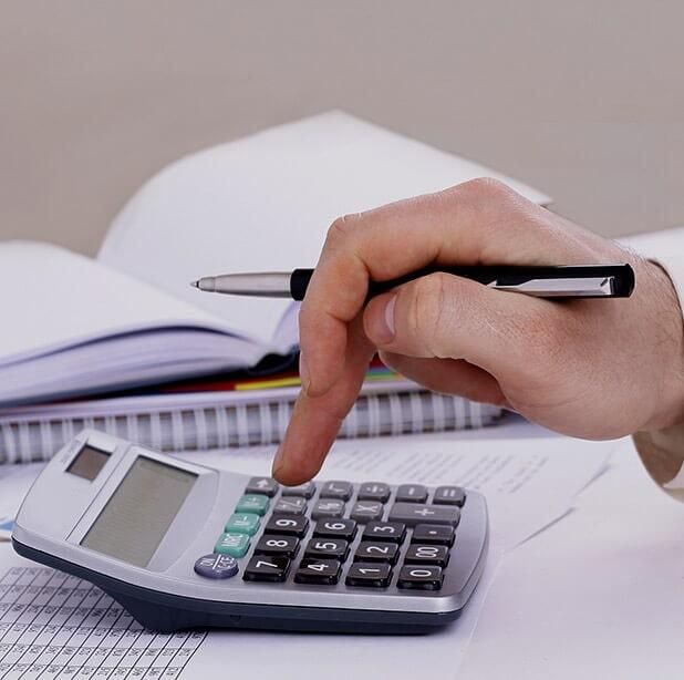 Una persona está usando una calculadora con un bolígrafo en la mano.