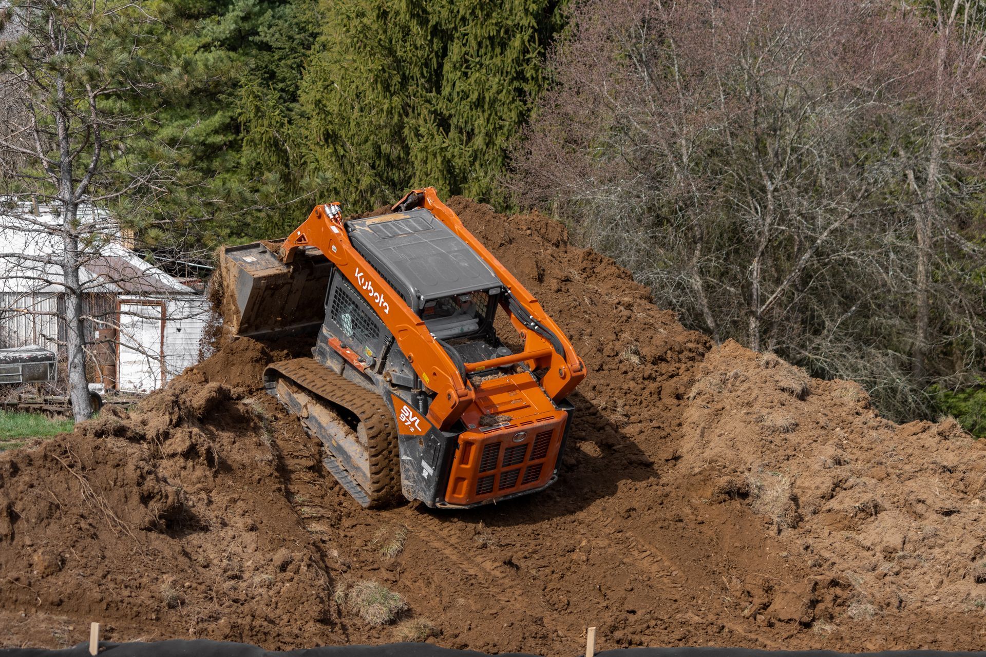 A bulldozer is sitting on top of a pile of dirt.