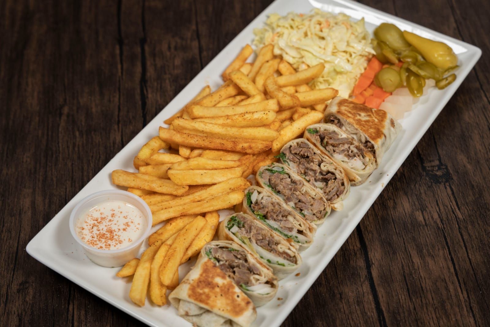 There is a plate of food with french fries and a sandwich on it.