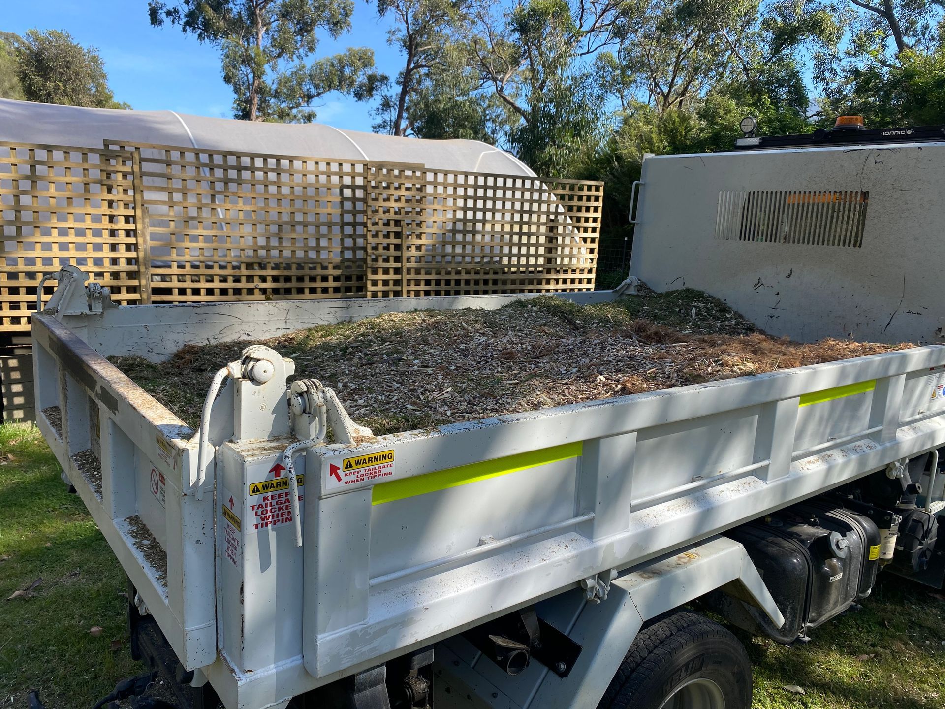 A truck is parked in a yard next to a house.