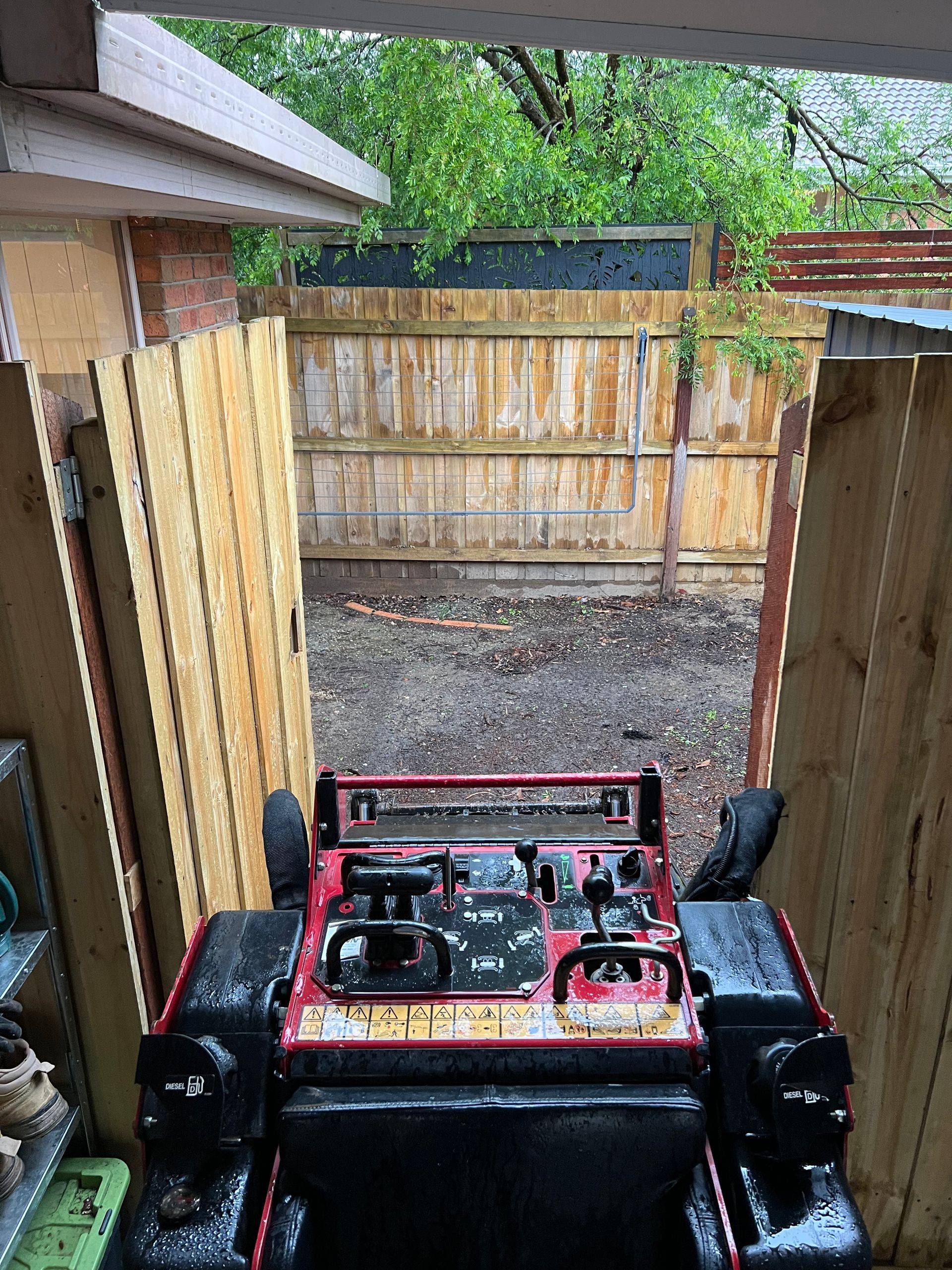 A lush green yard with a fence and a house in the background.