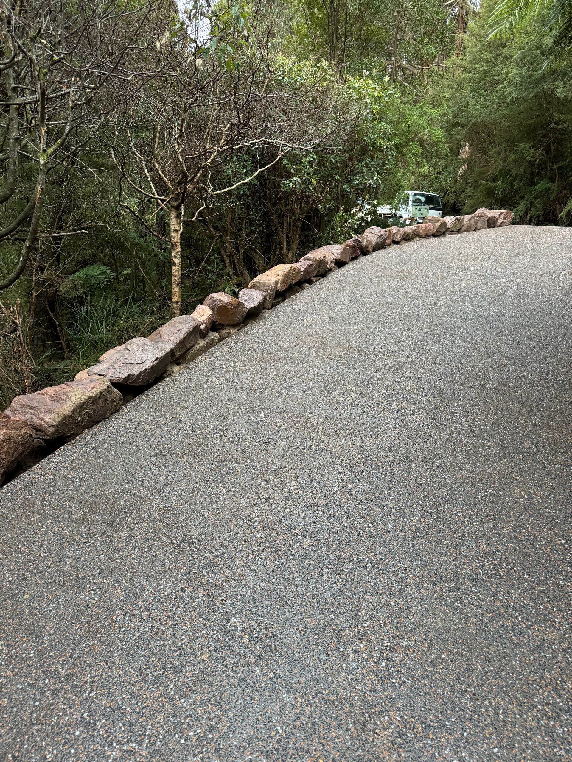 A brick building with a gravel driveway leading to it.