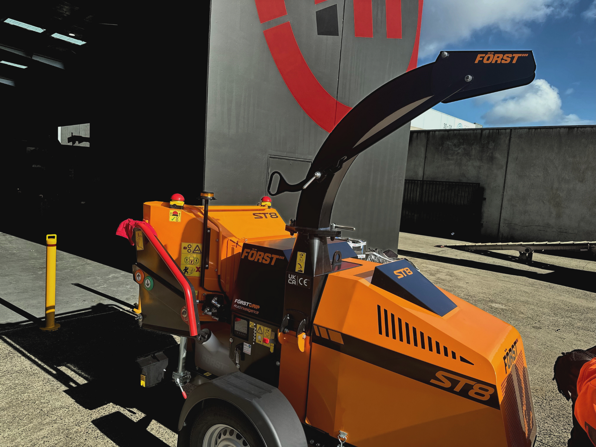 A forest st8 tree chipper is parked in front of a building