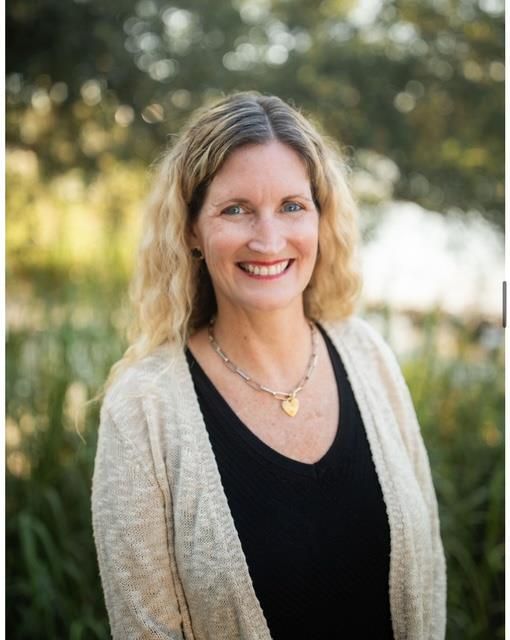 A woman without a face is wearing a suit and white shirt