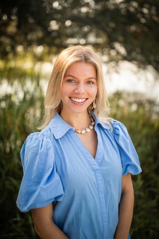 A woman without a face is wearing a suit and white shirt
