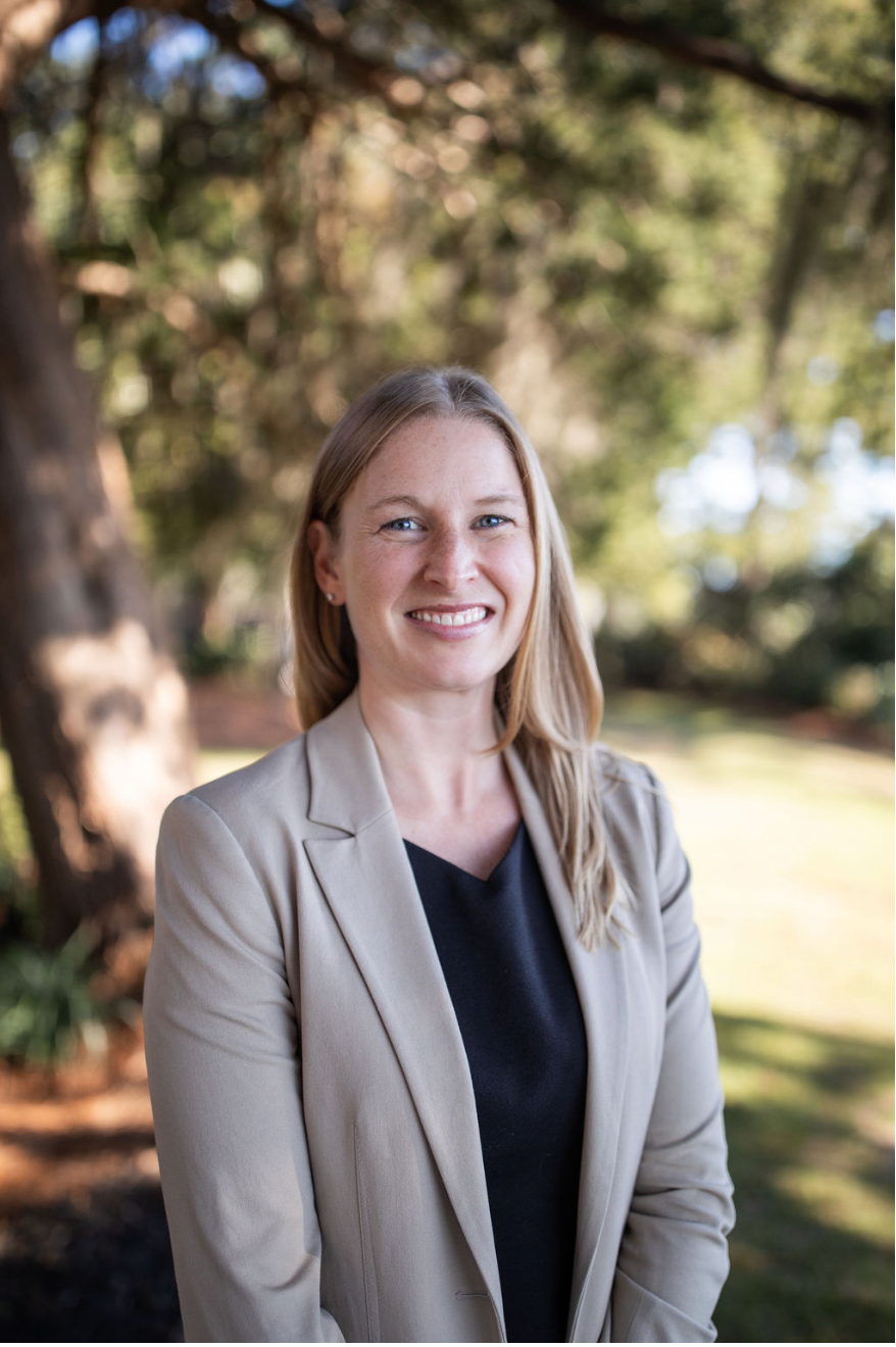 A woman with blonde hair and freckles is smiling for the camera.