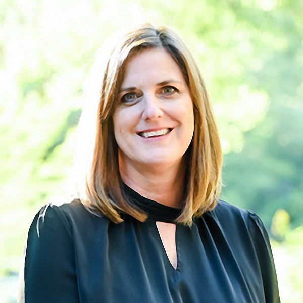 A woman in a black shirt is smiling for the camera.