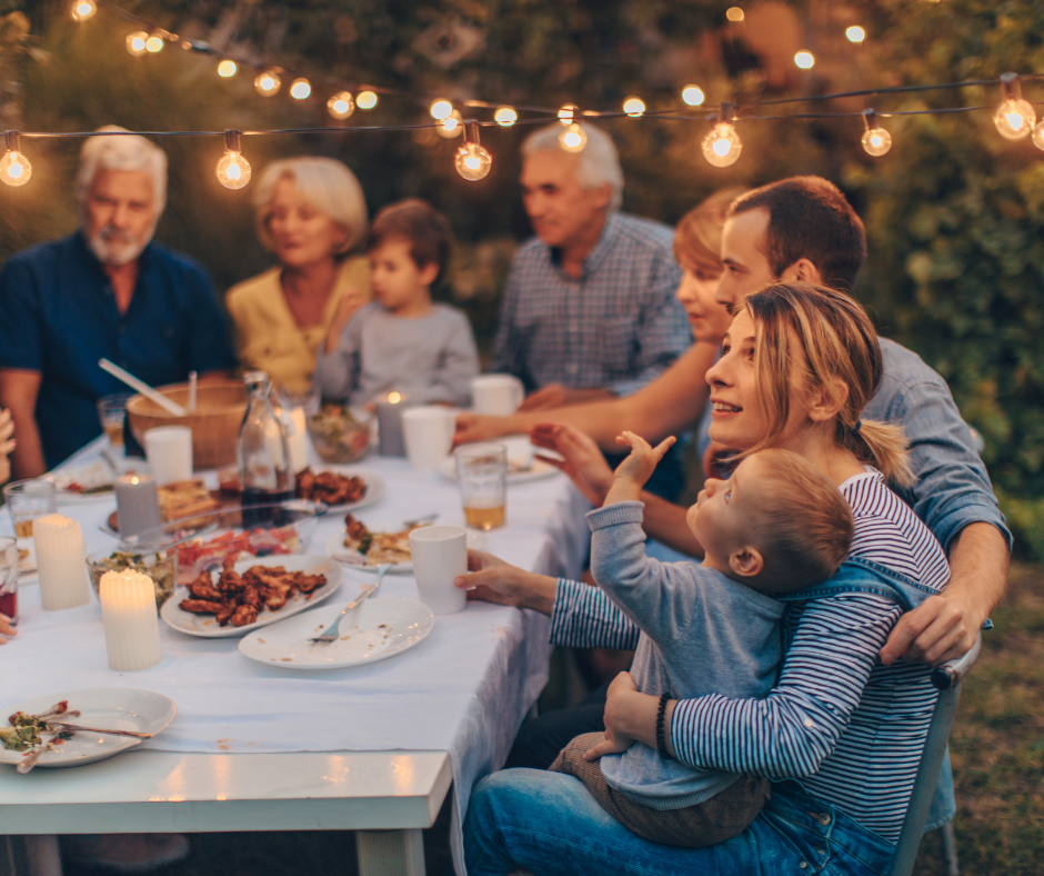 A group of people are sitting around a table eating food.