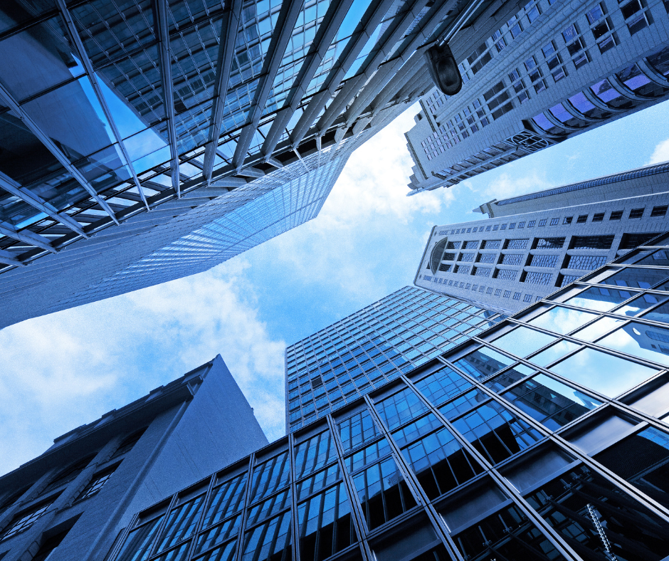 Looking up at skyscrapers with a blue sky in the background