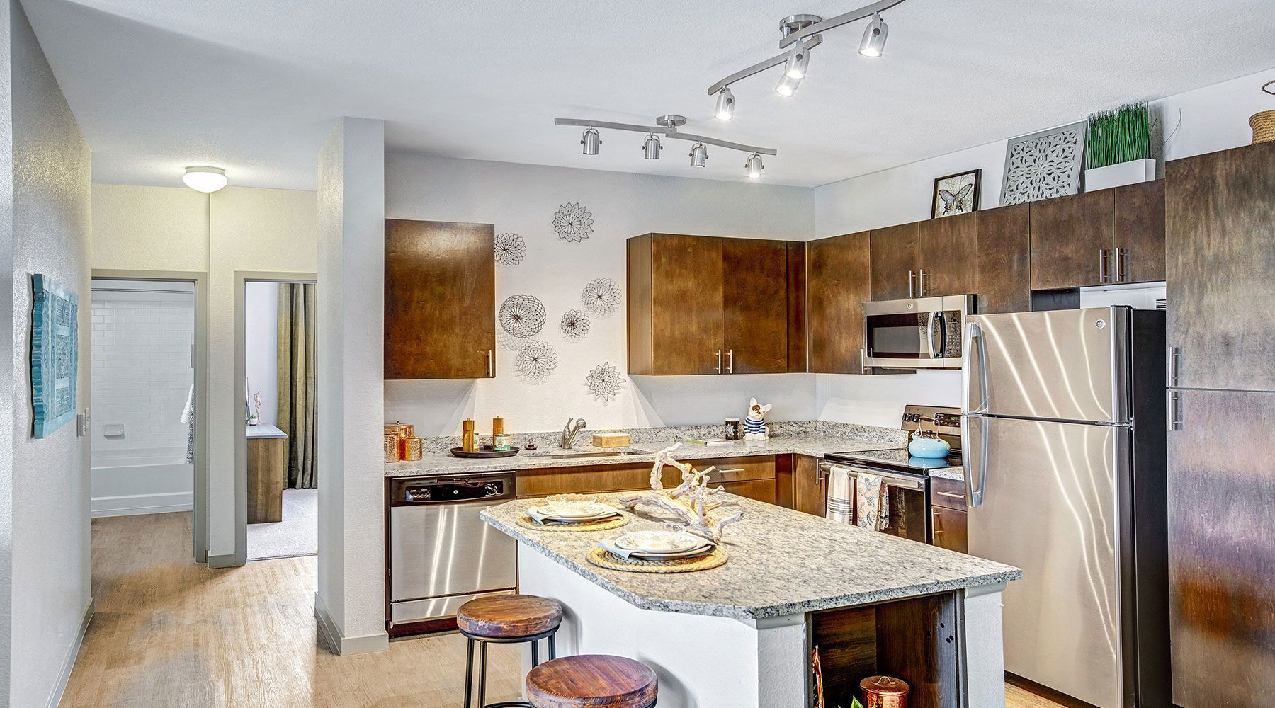 Modern kitchen with island, stainless steel appliances, and dark wood cabinets.