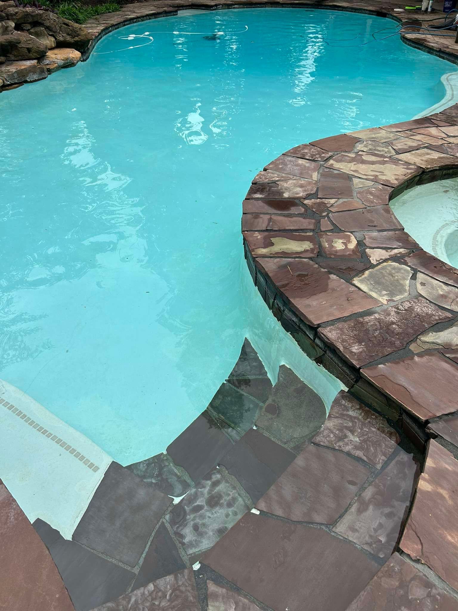 Pool with light blue water and stone surround.