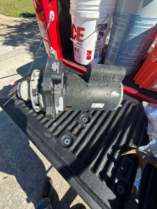 Black motor on a truck bed with white buckets and red tailgate.