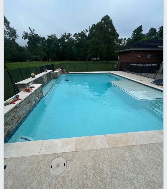Pool and hot tub on a sunny day with contrail in the sky. Trees and pergola in view.
