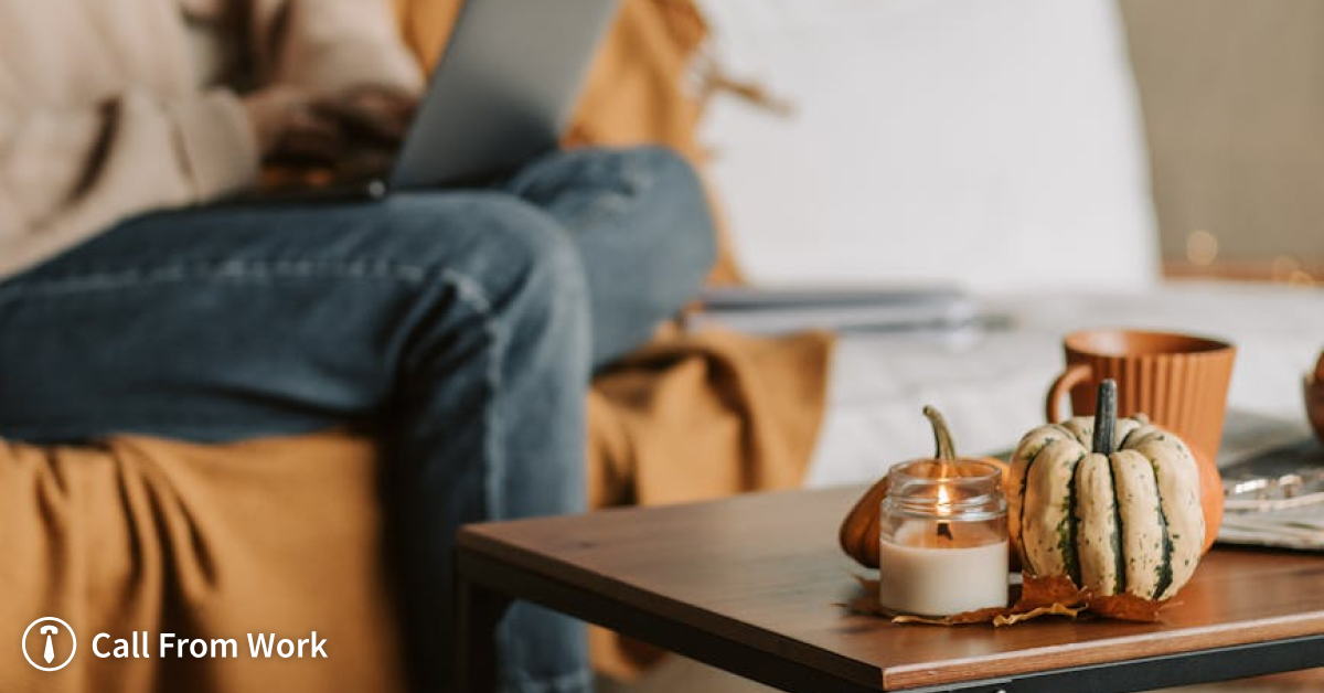 A person is sitting on a couch using a laptop.