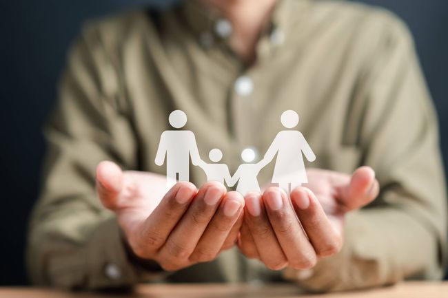 a man is holding a paper cut out of a family in his hands