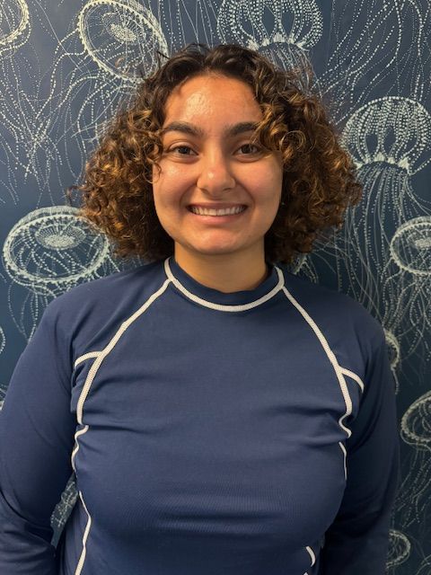 A woman with curly hair is wearing a blue shirt