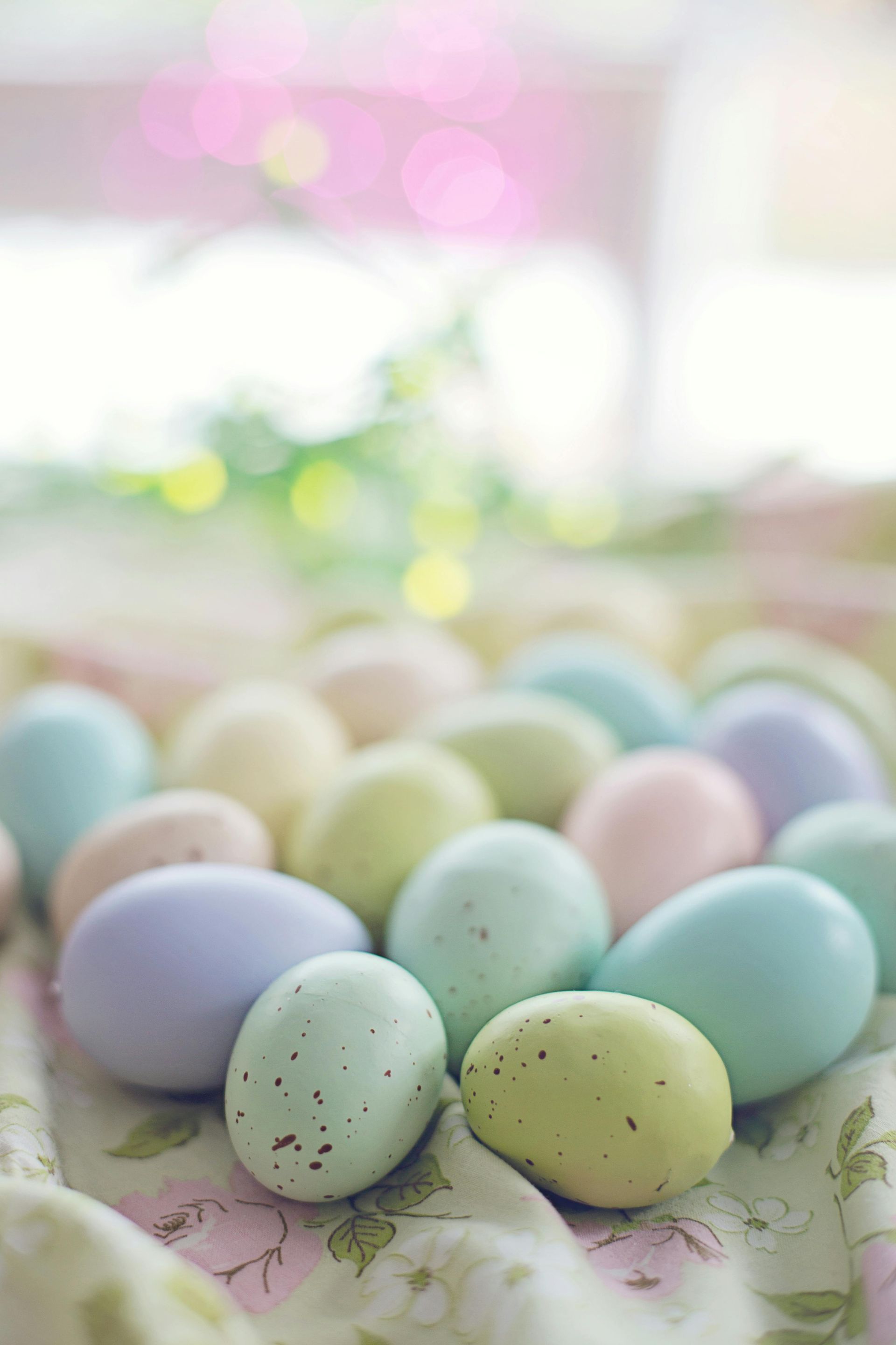 A pile of pastel coloured Easter eggs are close up to the camera.