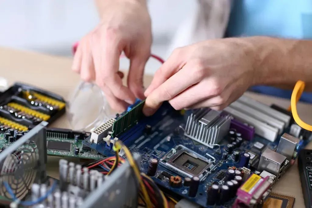 A man is working on a computer motherboard.