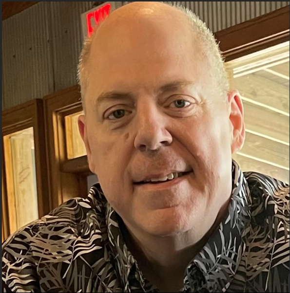 A man in a striped shirt is smiling for the camera