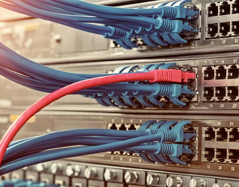 A bunch of cables are connected to a server in a data center.
