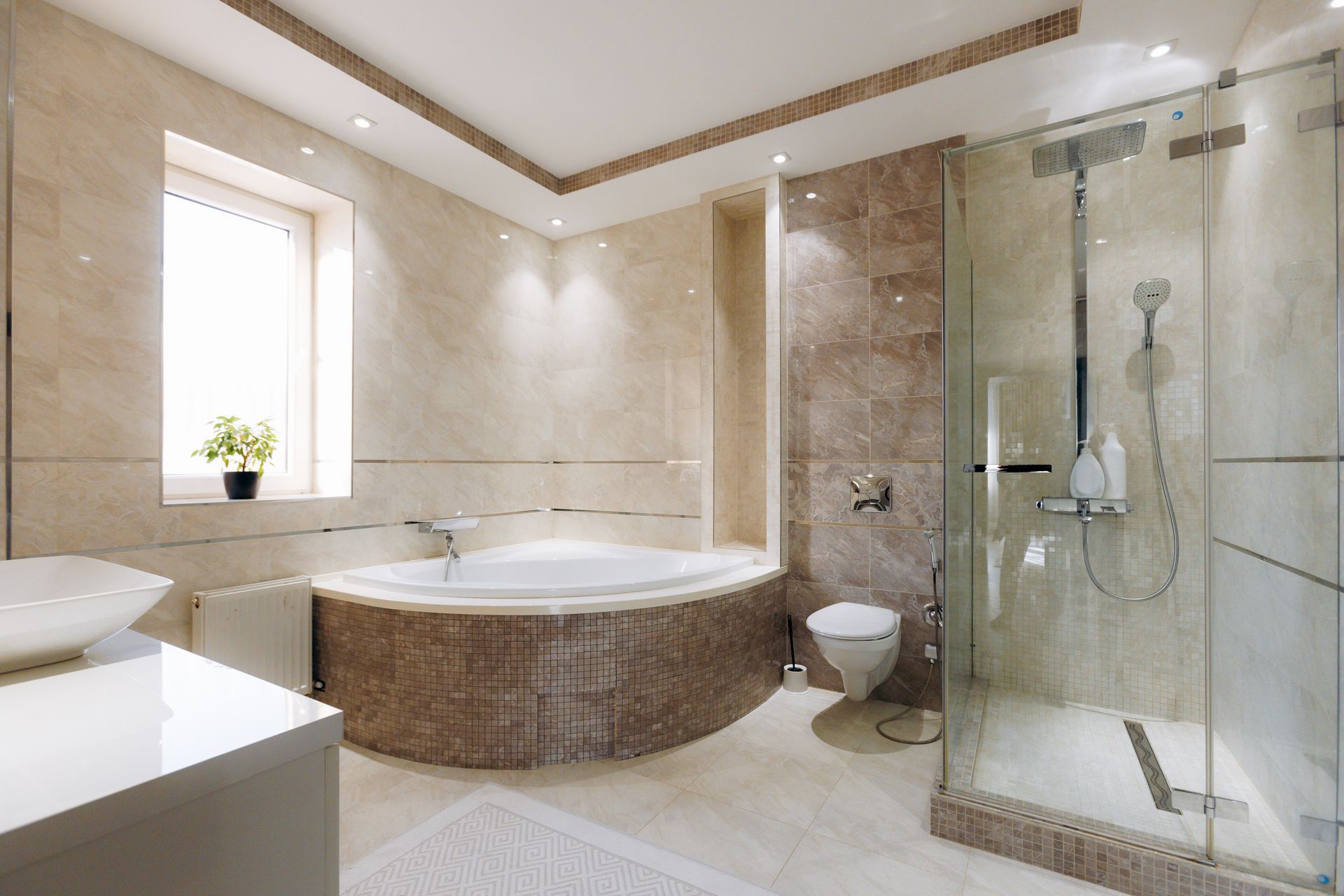 Luxurious bathroom with a circular tub, glass shower, and beige marble walls.