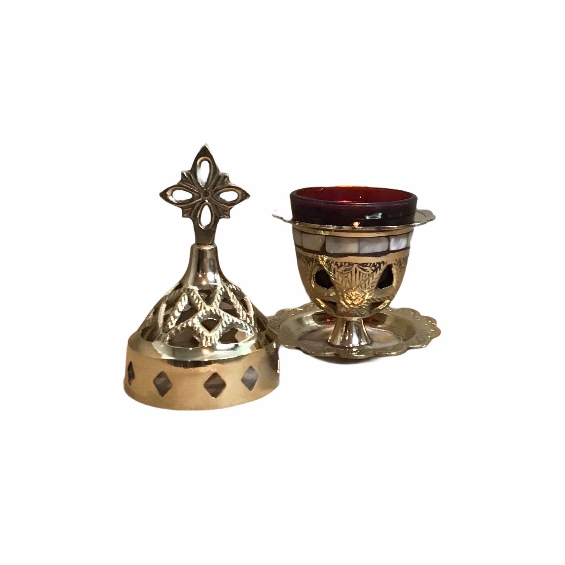 Een kandelaar van messing met een kruis erop op een witte achtergrond.