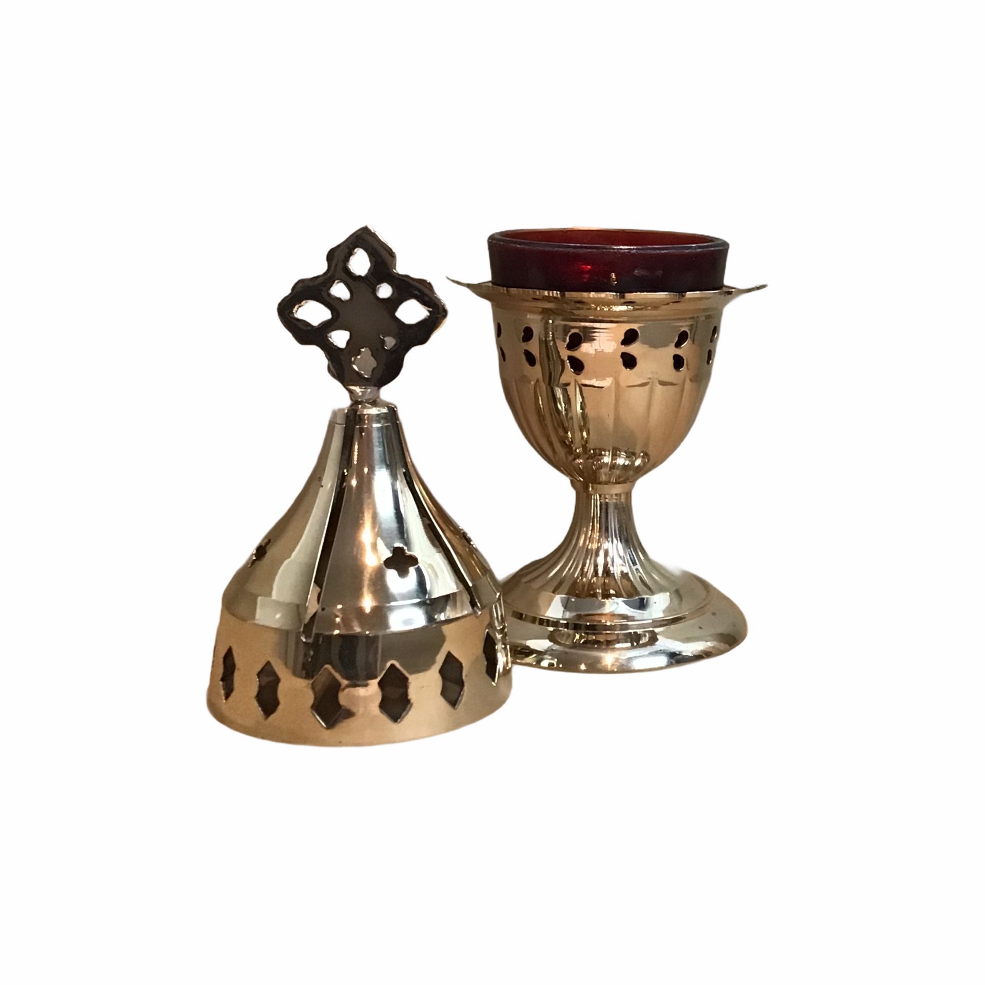 Een kandelaar van messing met een kruis erop op een witte achtergrond.