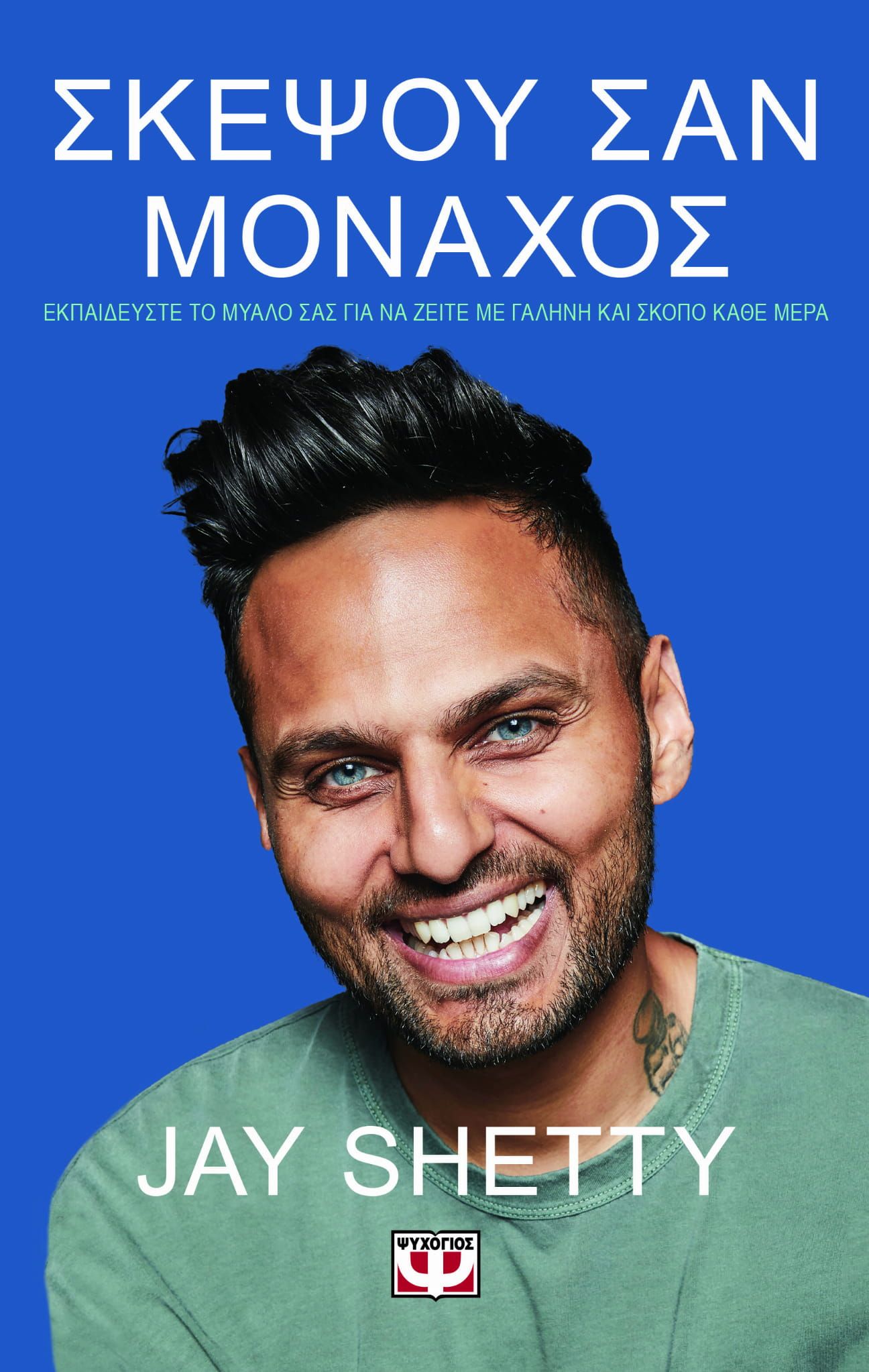 Een man met blauwe ogen lacht op de cover van een boek van jay shetty