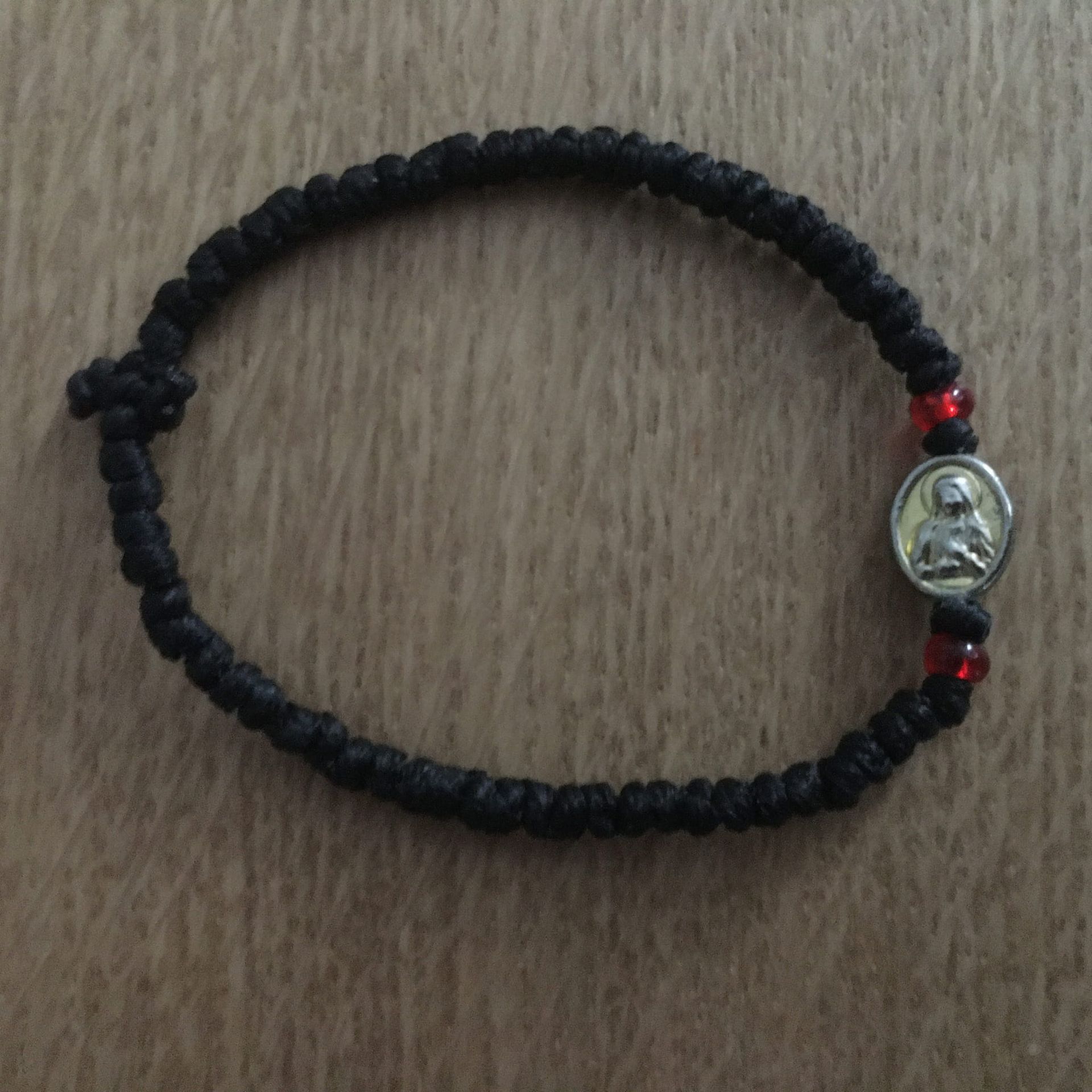 Een zwarte armband met een afbeelding van Jezus erop