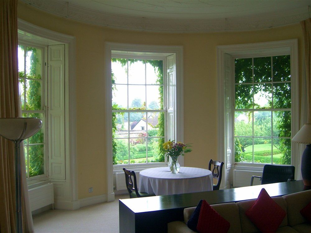 A living room with a table and chairs in front of a window. Devine Shine Window Cleaning Canton MI.