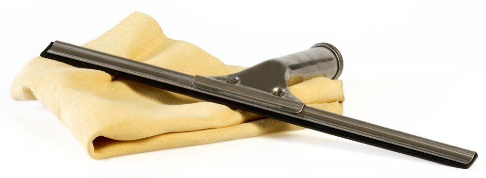 A squeegee is laying on top of a yellow cloth. Devine Shine Window Cleaning Canton MI.