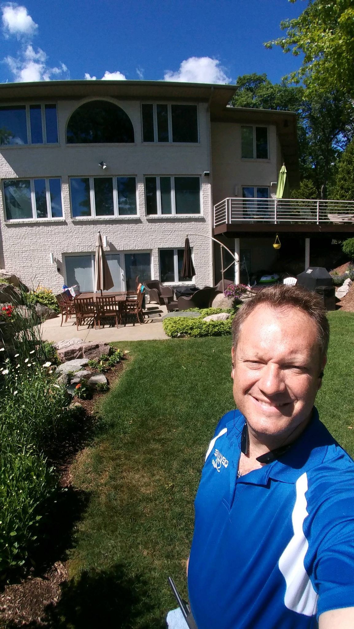 A man taking a selfie in front of a large house. Devine Shine Window Cleaning Canton MI.
