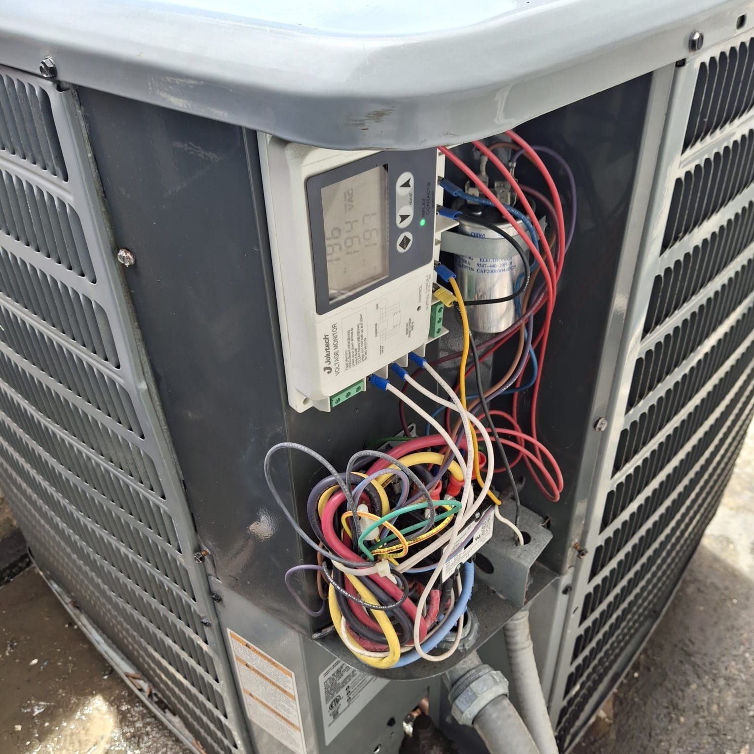 El interior de un acondicionador de aire con un montón de cables saliendo de él.