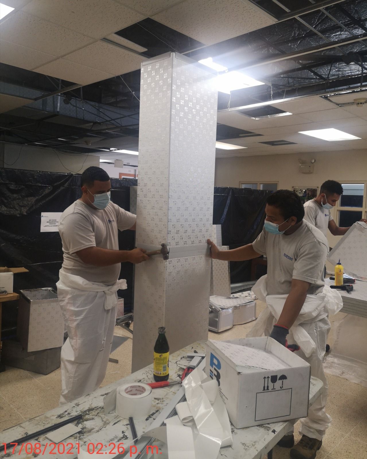 Un grupo de hombres con máscaras están trabajando en una pared.