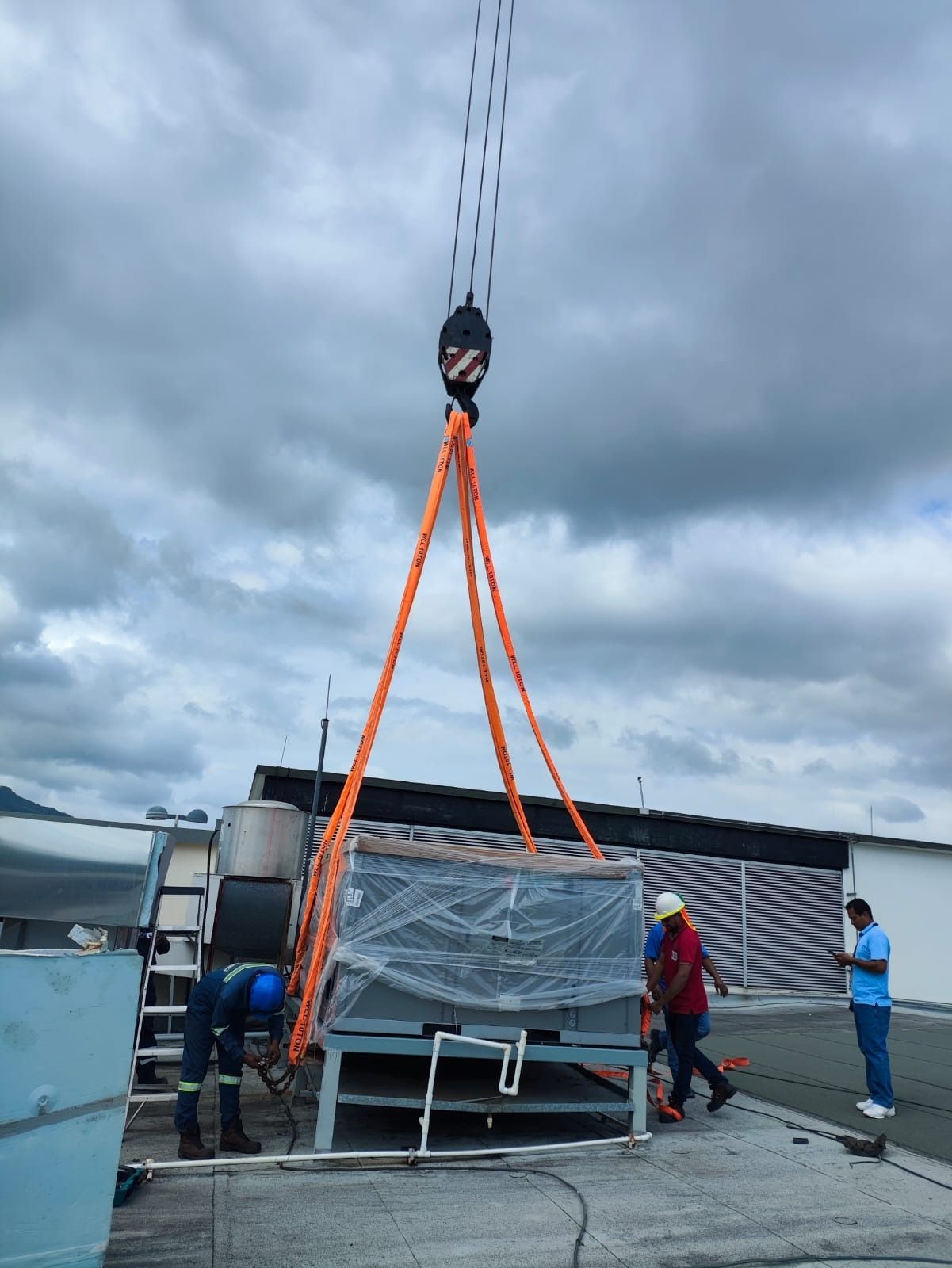Se está utilizando una grúa para levantar una caja grande.