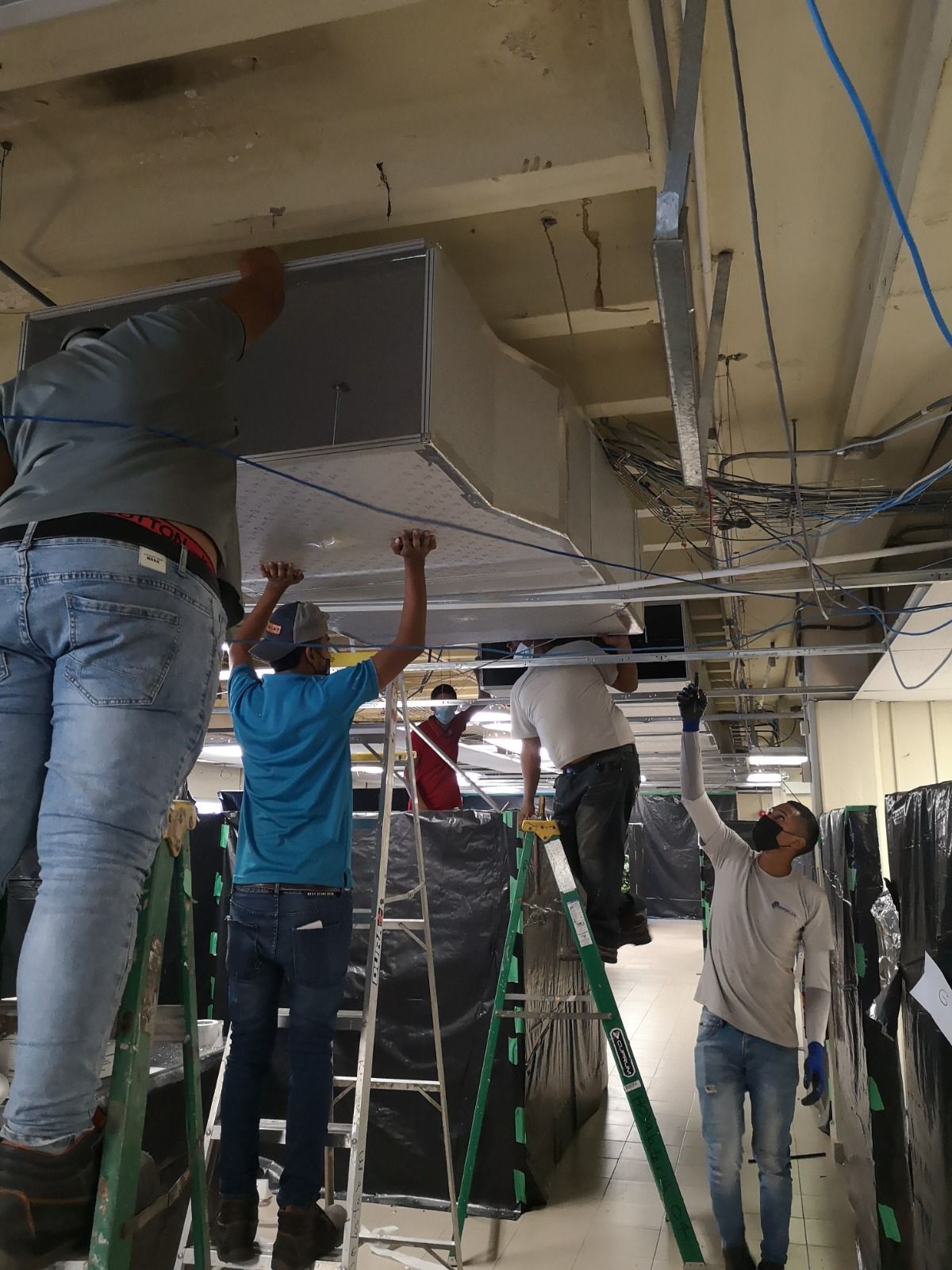 Un grupo de hombres está trabajando en el techo de un edificio.