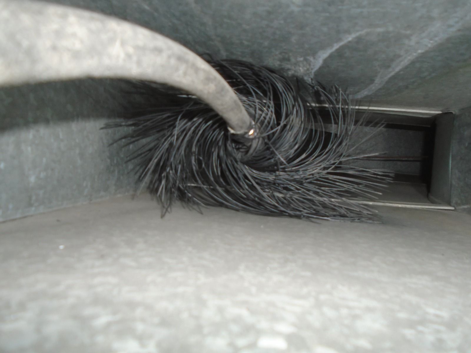 Se está utilizando un cepillo para limpiar un conducto en una habitación.