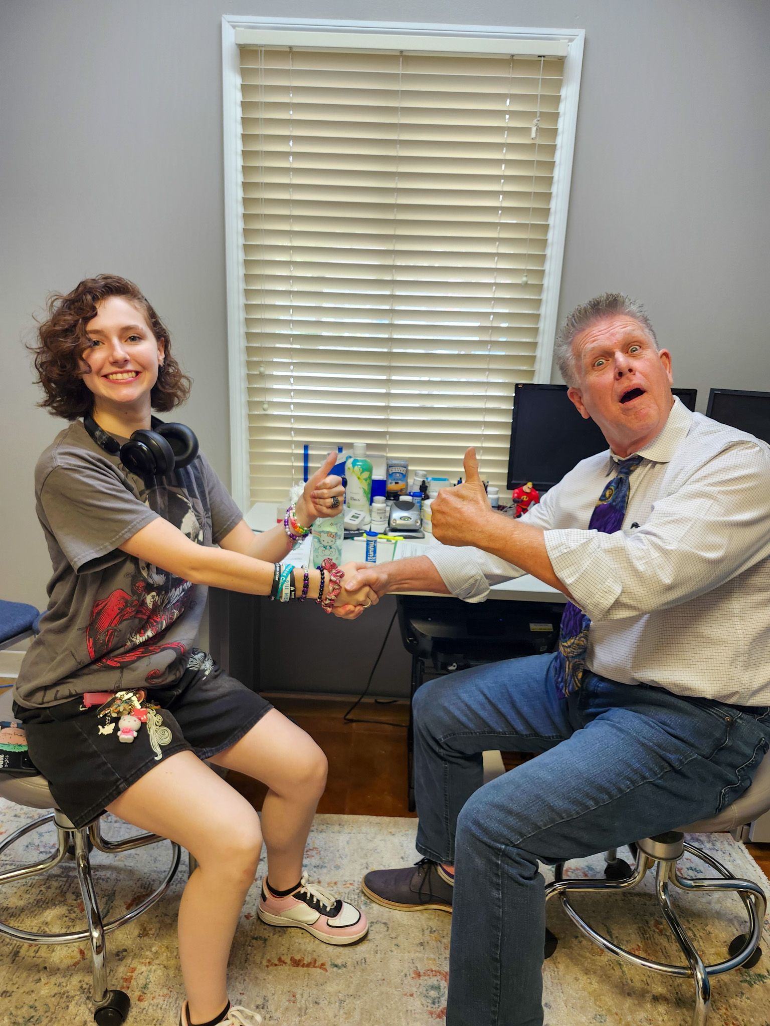 A man and a woman are shaking hands in a room.
