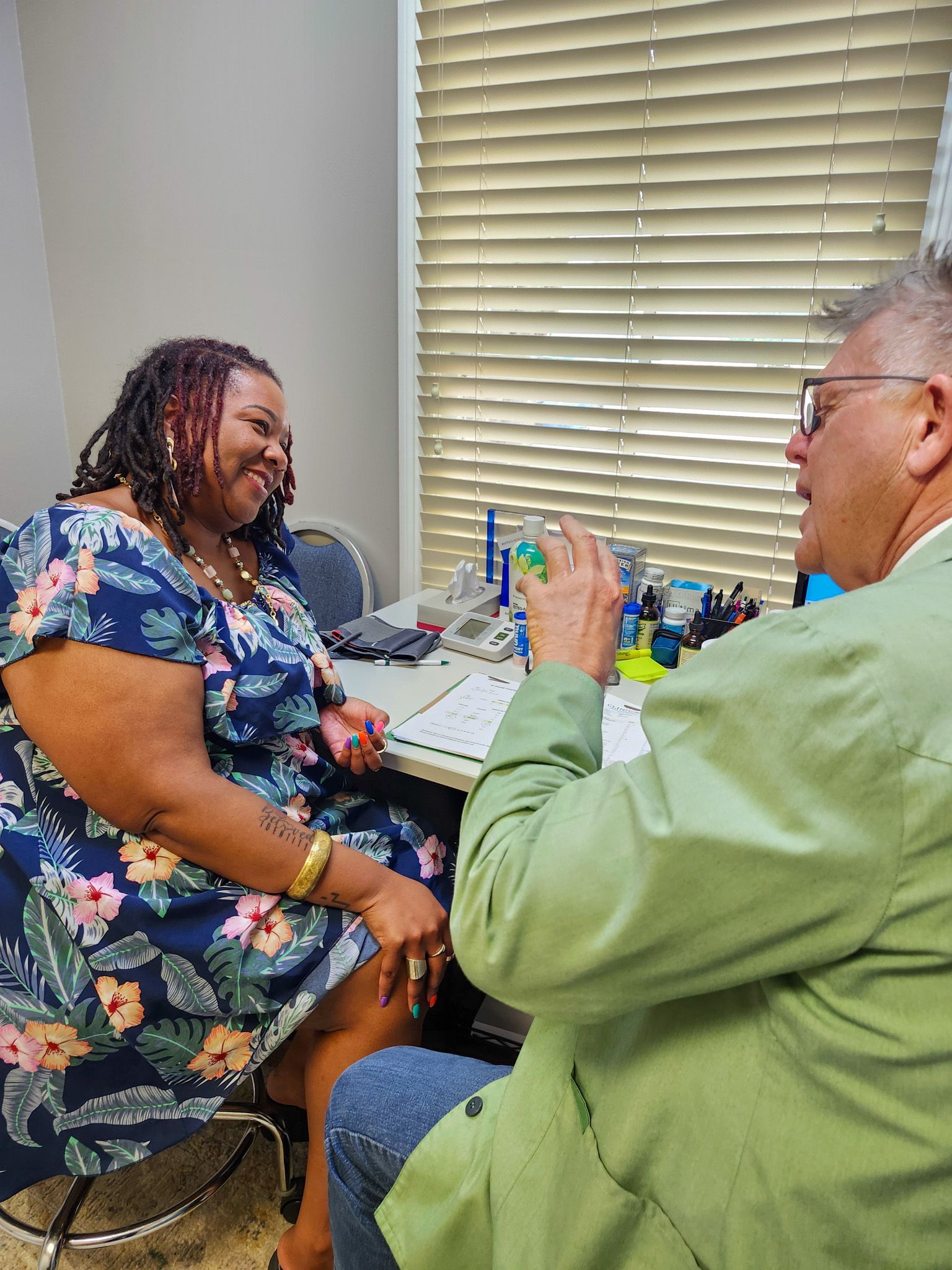 A man and a woman are sitting at a table talking to each other.