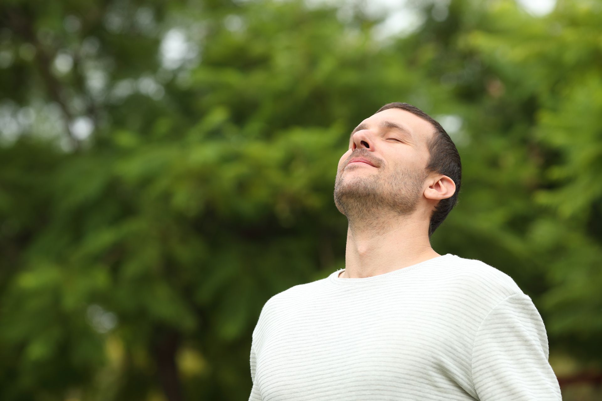 A man is breathing fresh air in a park