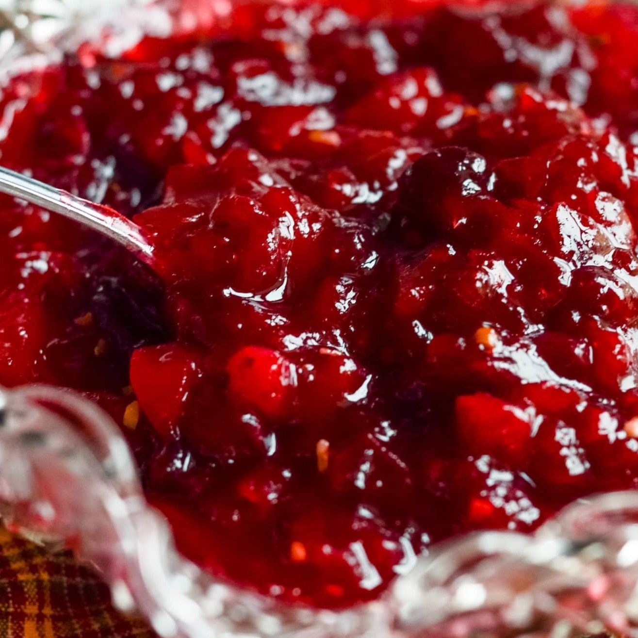 A bowl of cranberry sauce with a spoon in it