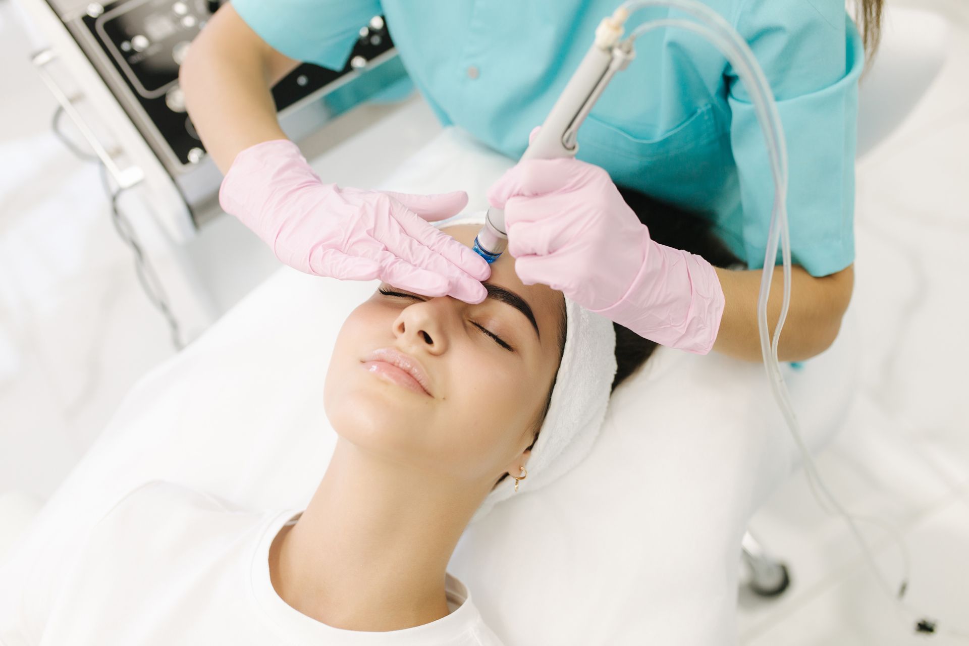 A woman is getting a Hydrafacial facial treatment.