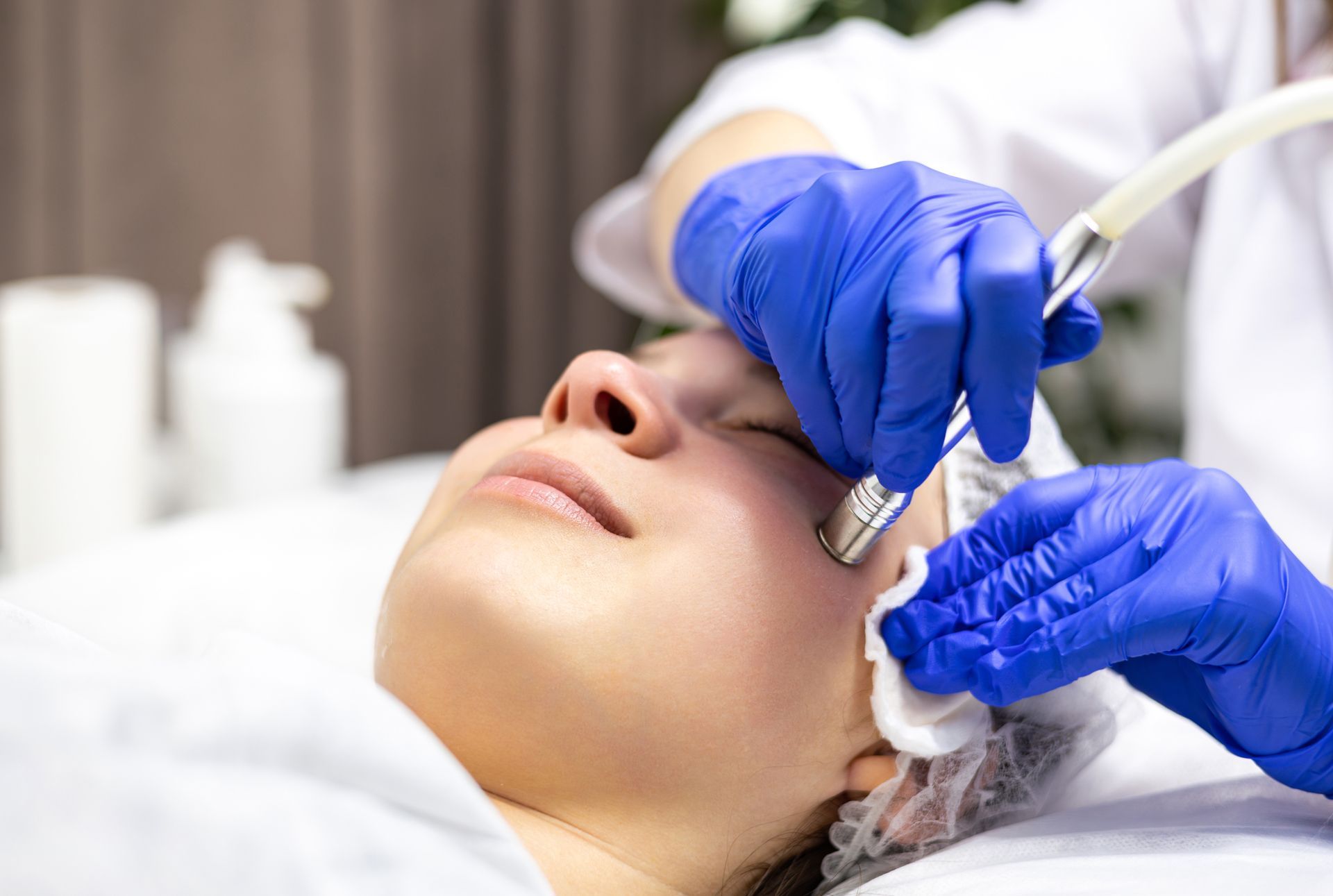 A woman is getting a facial Micro-Dermabrasion treatment.