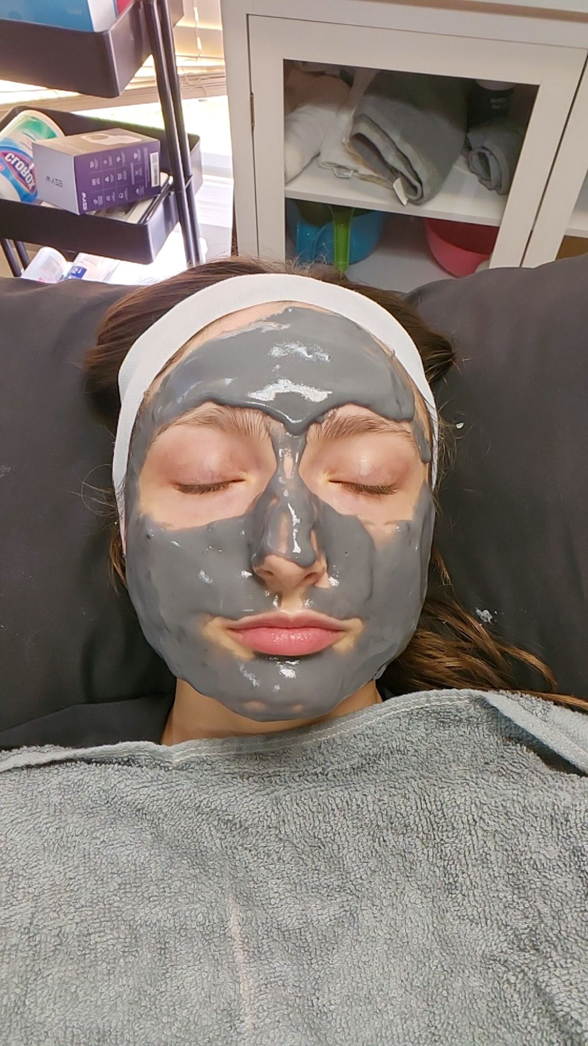A woman is wearing a gray mask on her face.