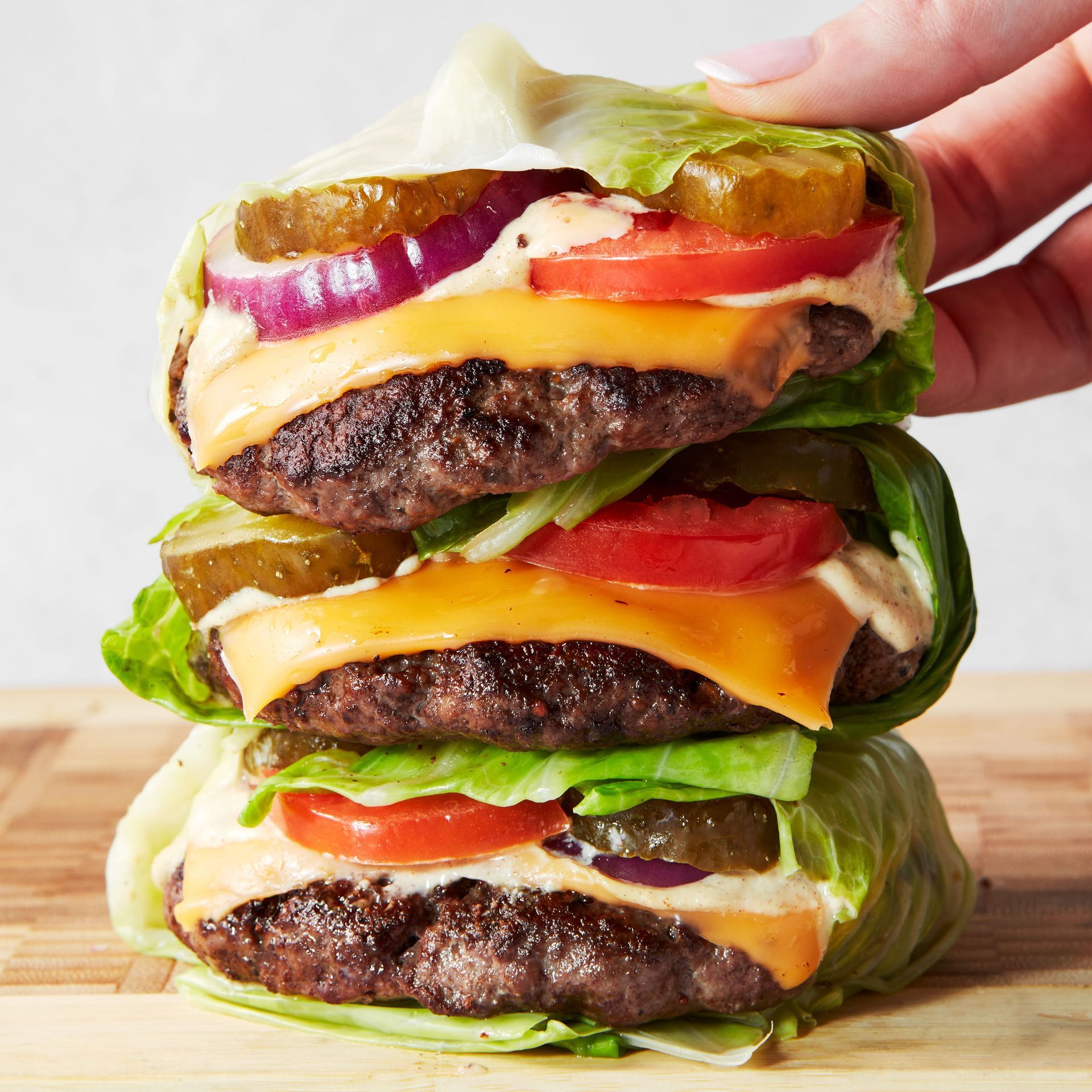 A person is holding a hamburger stacked on top of each other.