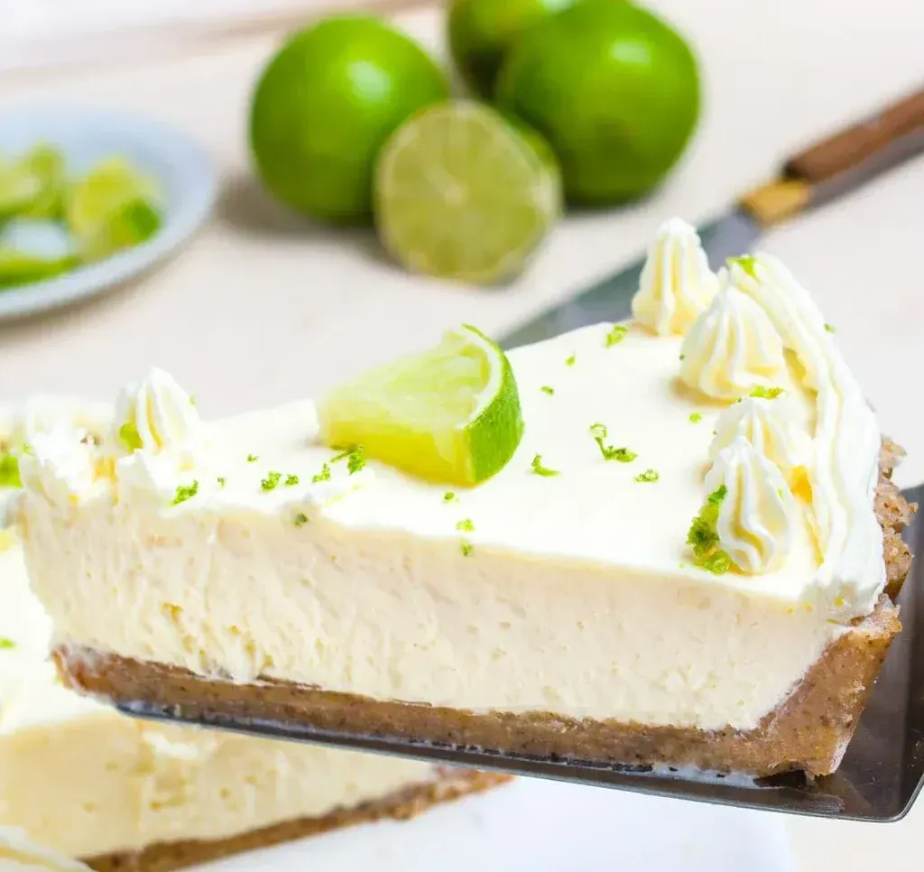 A slice of key lime pie is being served on a spatula.